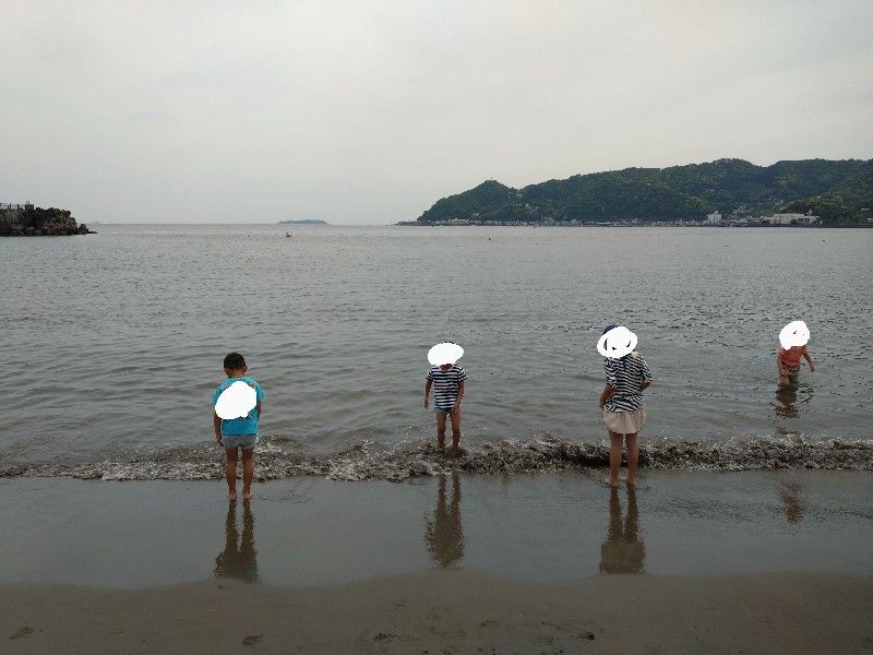 海岸でぴちゃぴちゃ水遊びのこどもちゃんたち