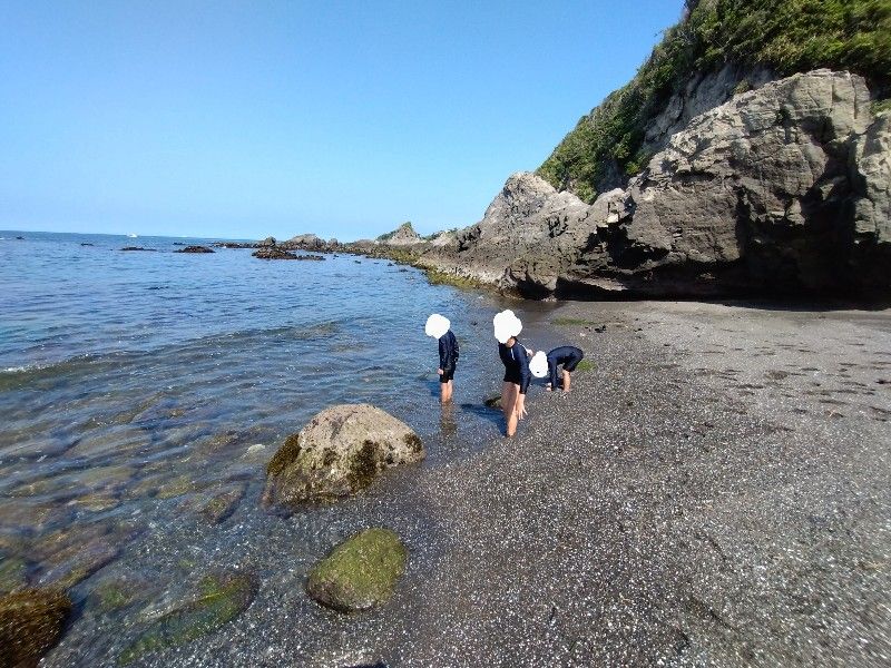 波打ち際で足浸しているこどもたち