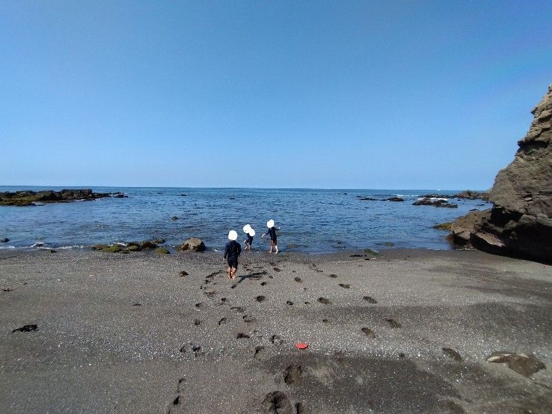 海に歩いて行く3人のこども